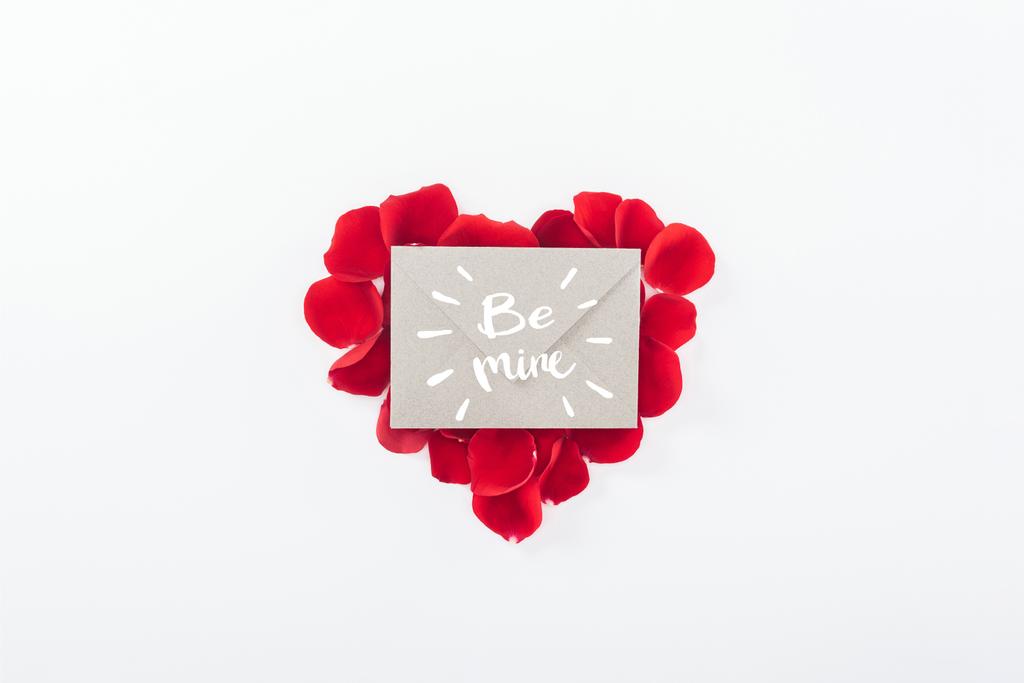 верхний вид конверта с надписью "будь моим" и сердце из красных лепестков роз, выделенных на белом, День Святого Валентина концепции
 - Фото, изображение