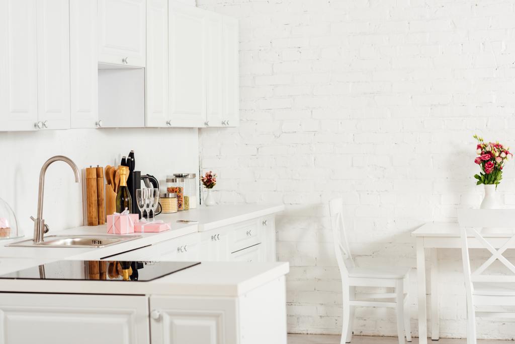 Дизайн інтер'єру кухні з білими меблями та індукційною плитою
 - Фото, зображення