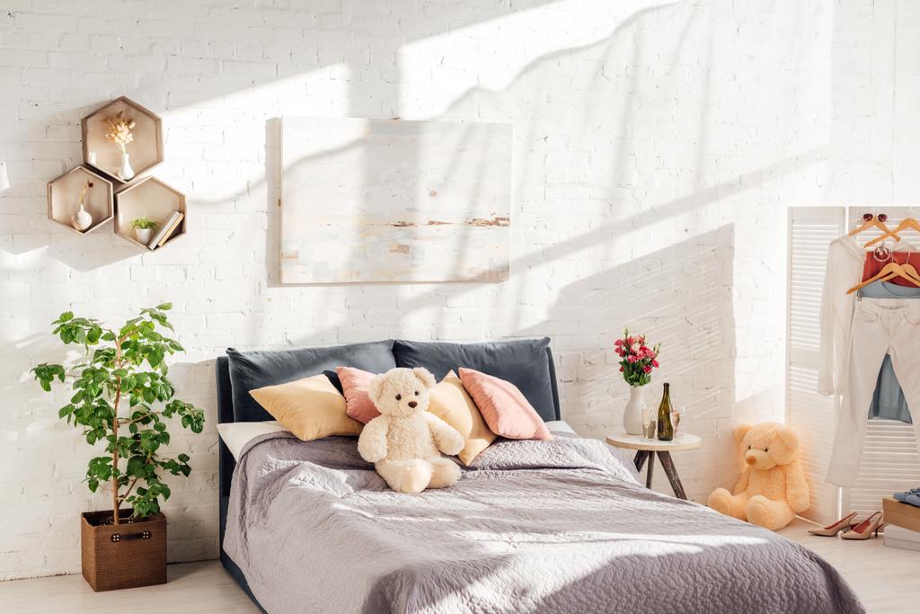 diseño interior moderno de dormitorio con juguetes de peluche, almohadas, plantas y cama
 - Foto, Imagen