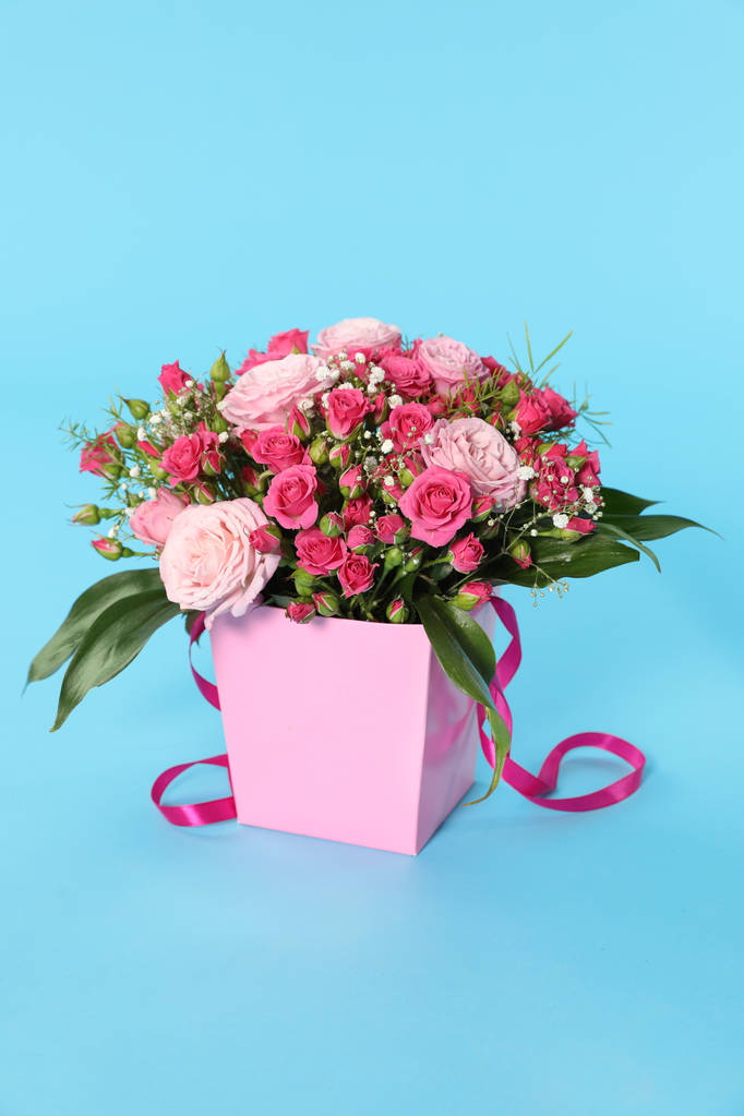Güzel buket çiçek kağıt hediye kutusunda renk arka plan üzerinde - Fotoğraf, Görsel