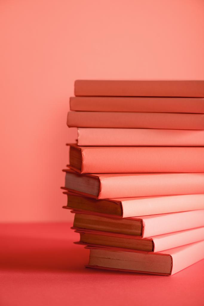 pile of books on living coral background. Pantone color of the year 2019 concept - Photo, Image