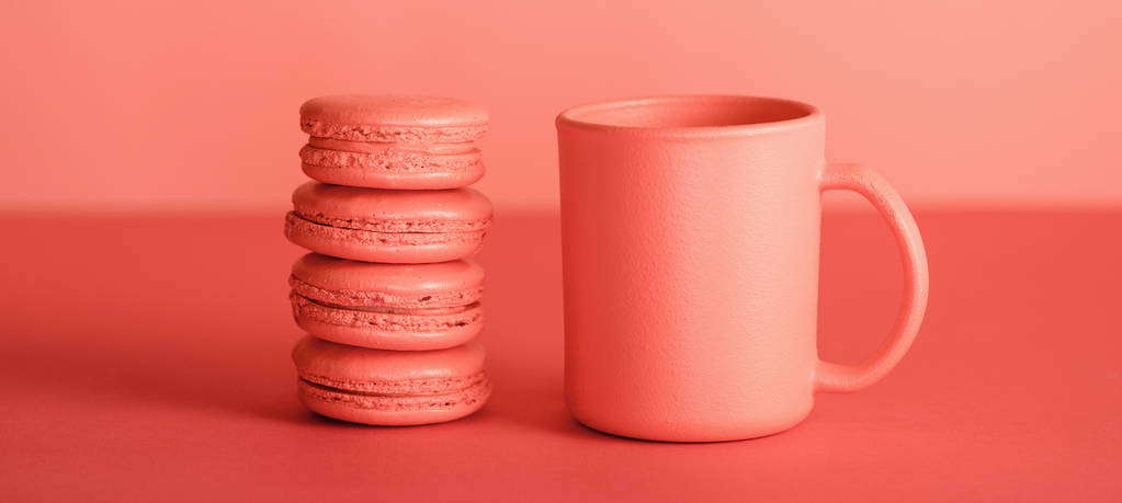 一杯のコーヒーと生きているサンゴ色のマカロン。2019 年概念の Pantone カラー - 写真・画像