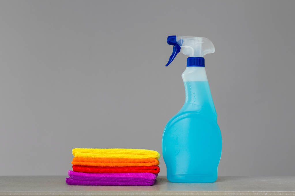 Um conjunto de roupas de limpeza coloridas e um agente de limpeza em frasco de spray azul. Lugar para SMS. Conceito Primavera limpeza
. - Foto, Imagem