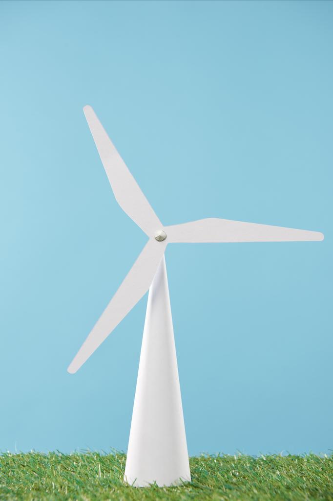 modelo de molino de viento blanco sobre hierba verde y fondo azul
 - Foto, Imagen