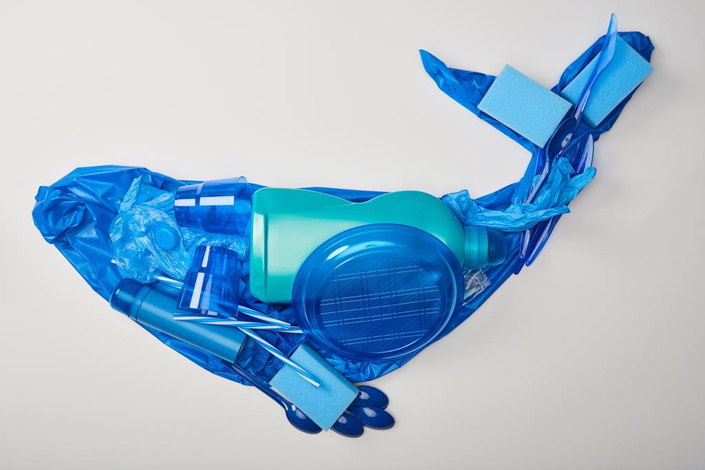vista superior de ballena hecha de vajilla de plástico desechable, bolsa, botella, esponjas y guantes de goma aislados en blanco
 - Foto, imagen