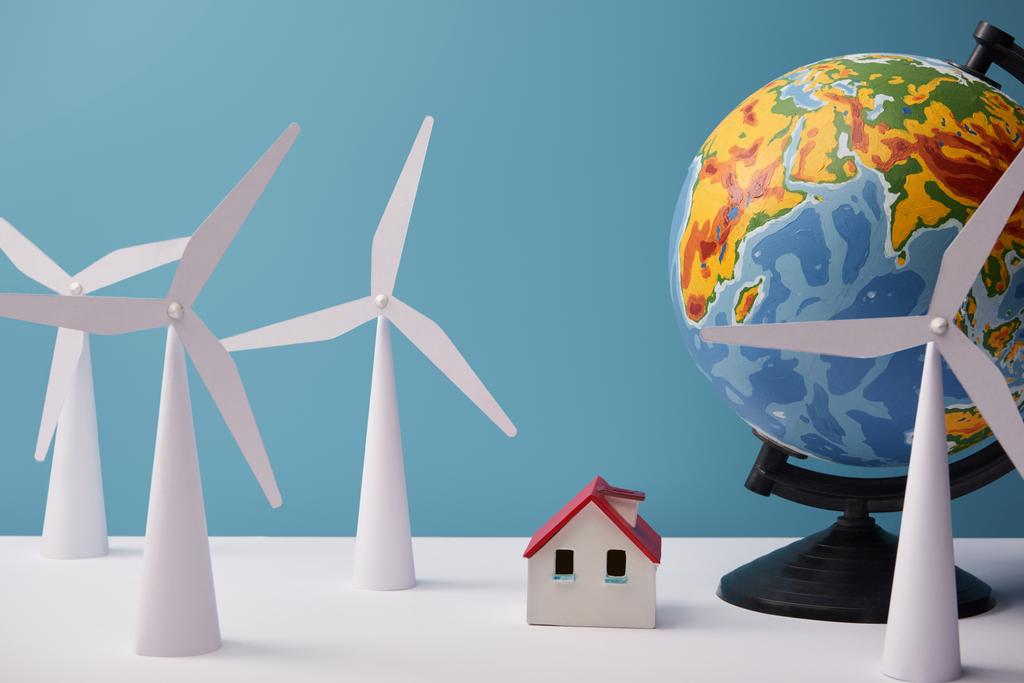 modelos de moinho de vento e casa com globo na mesa branca e fundo azul
 - Foto, Imagem