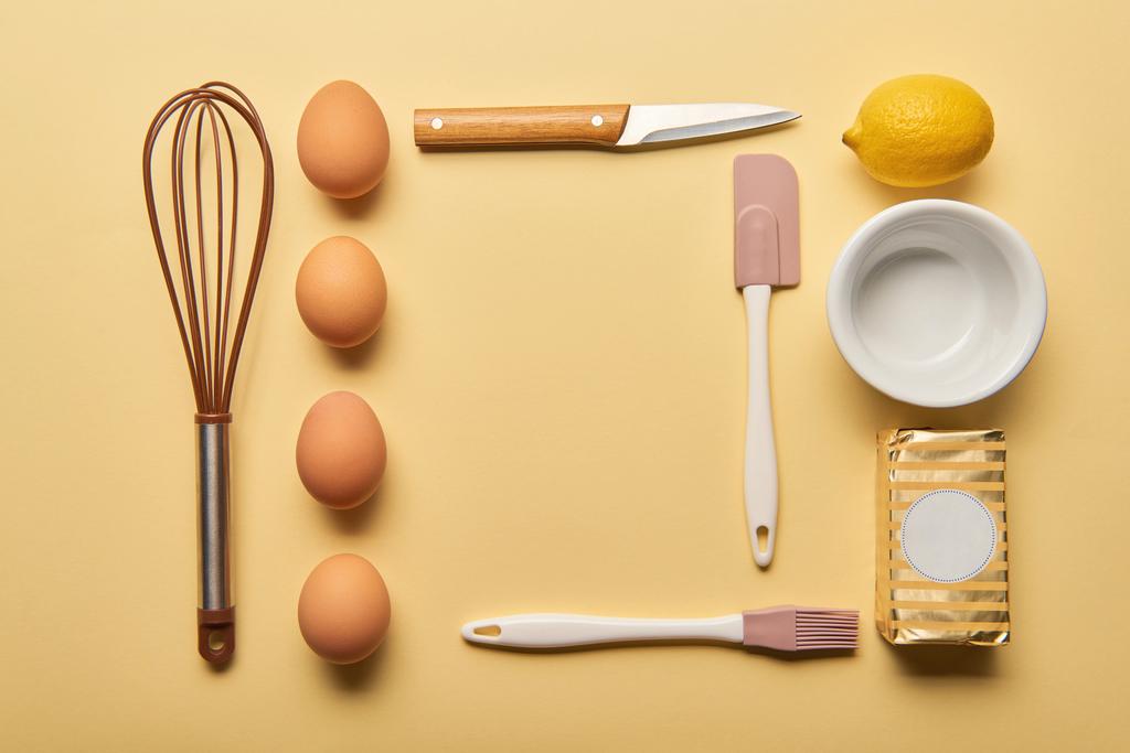 flat lay com utensílios de cozinha, limão, manteiga e ovos sobre fundo amarelo
 - Foto, Imagem
