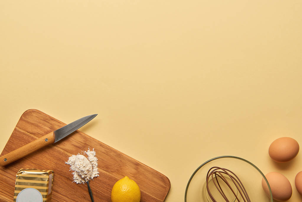 top view of ingredients and knife on wooden chopping board on yellow background  - Photo, Image