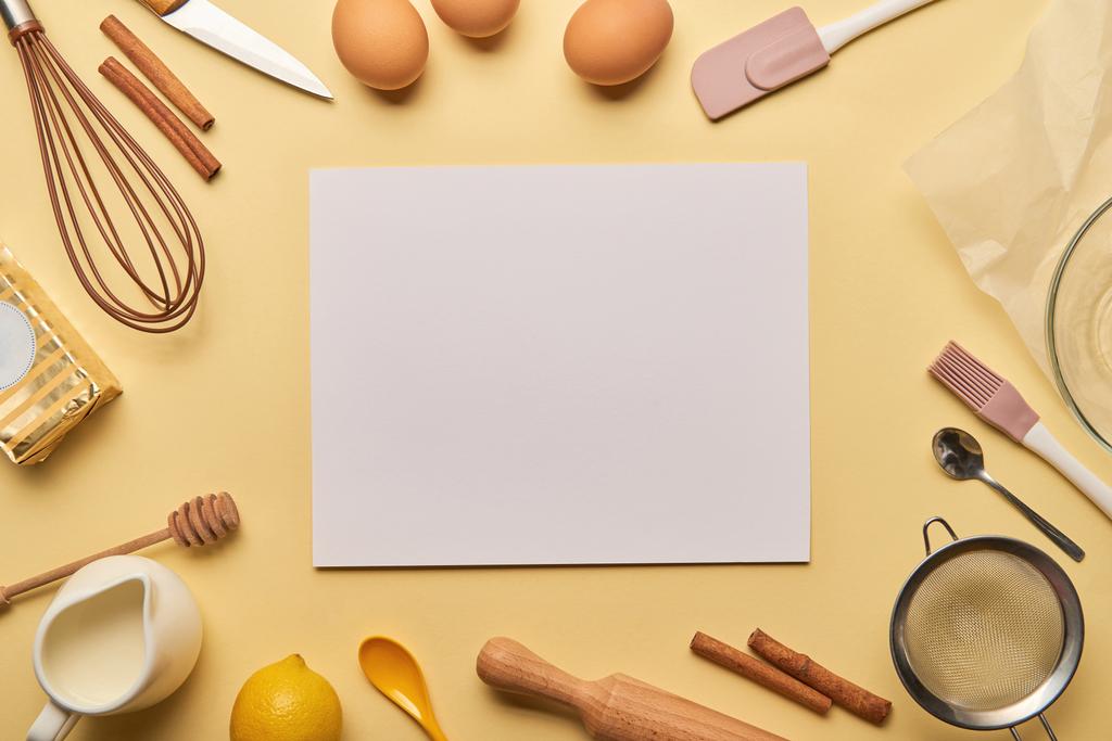 vista superior de los ingredientes de la panadería y utensilios de cocina alrededor de la tarjeta en blanco
 - Foto, imagen