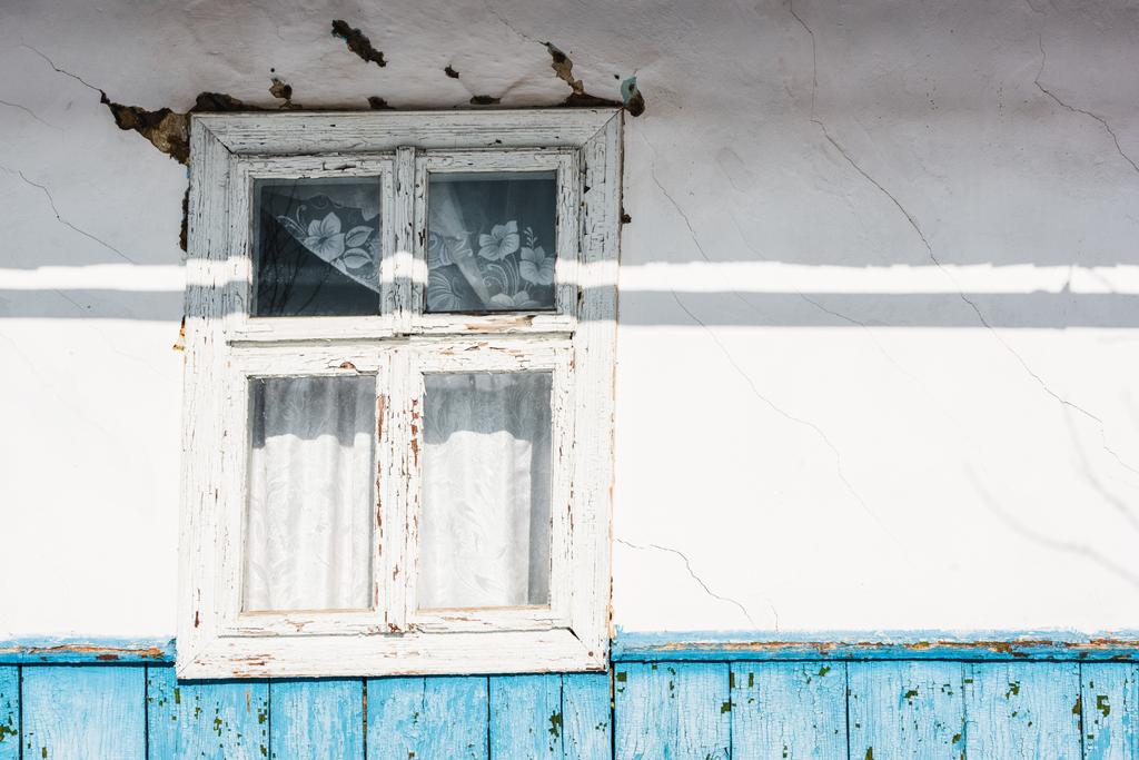 old weathered house with window, cracks and sunshine - Photo, Image