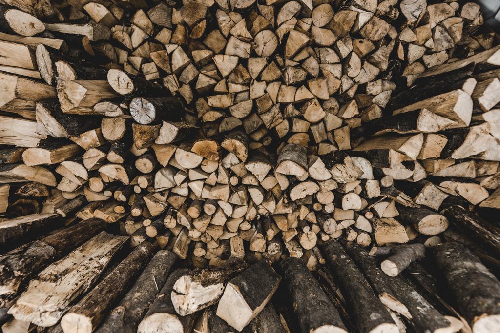 bovenaanzicht van bruin gestapeld brandhout te snijden  - Foto, afbeelding