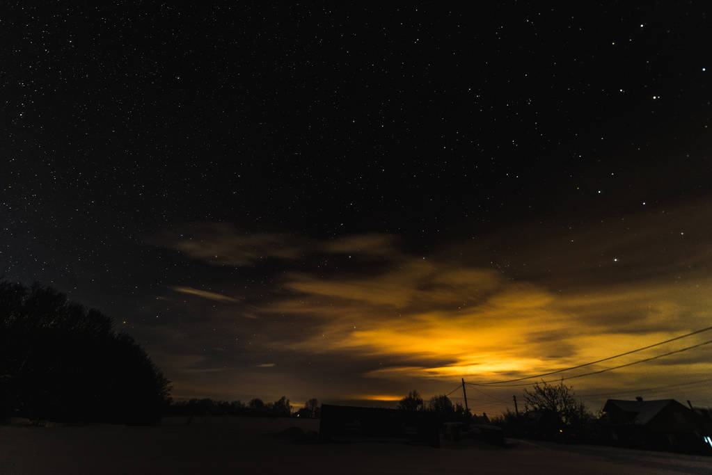 yıldızlı karanlık gökyüzü ve Karpat Dağları Sarı ışıkta kış geceleri - Fotoğraf, Görsel
