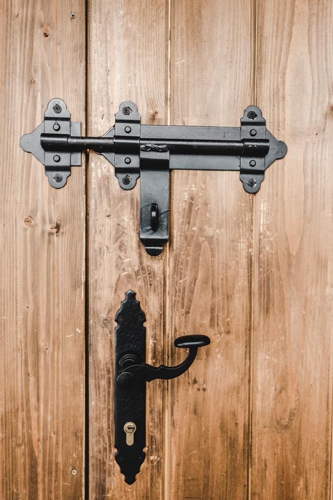 schwarzes Eisenschloß und Griff an beige strukturierter Holztür - Foto, Bild