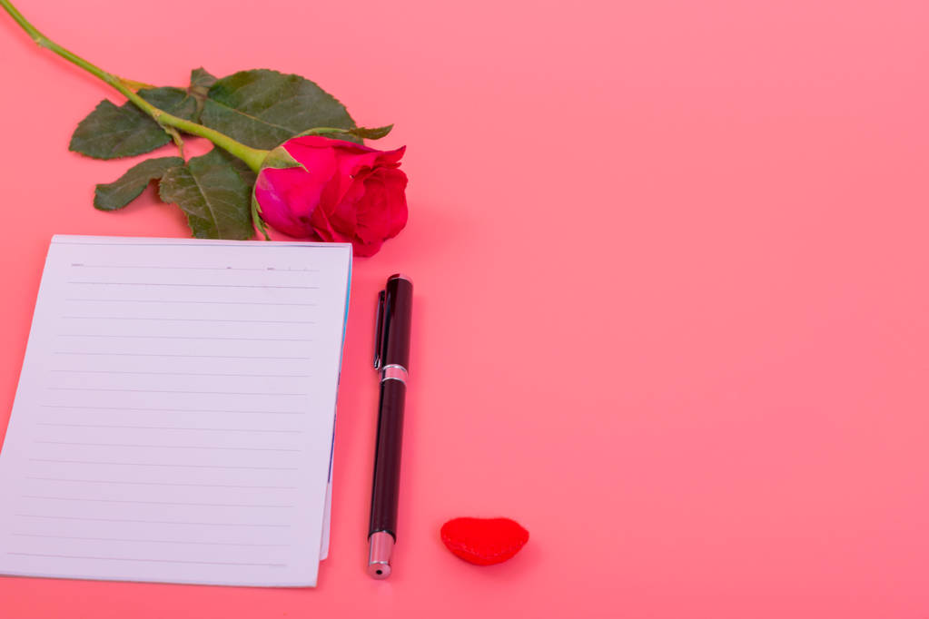 viele kleine Herzen in Herzschachtel mit rosa Rosen, Notiz mit Stift auf rosa Hintergrund - Foto, Bild