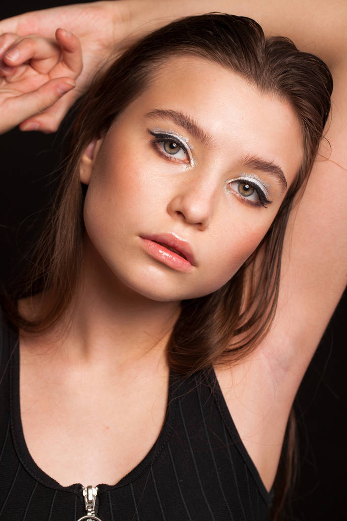 Close up Maquillaje modelo de moda. Joven hermosa chica morena, en el estudio negro fondo de la pared - Foto, Imagen
