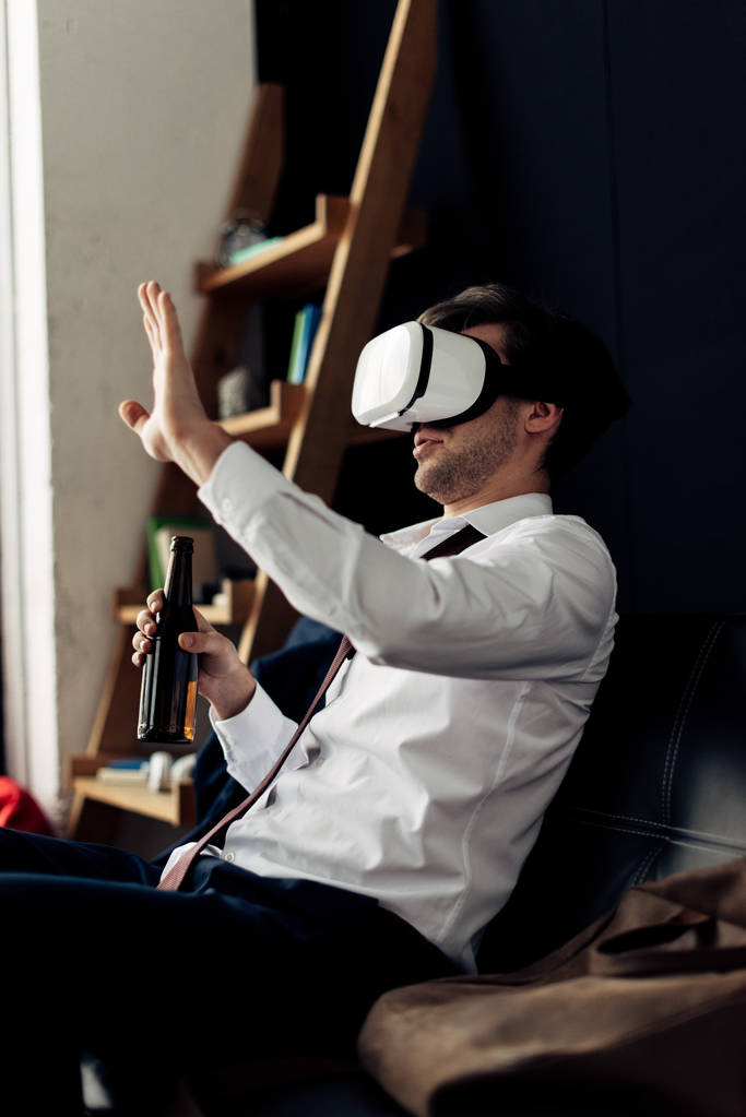 man wearing virtual reality headset and holding bottle of beer  - Photo, Image