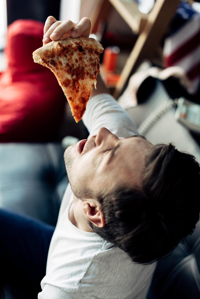 uomo ubriaco mettendo in bocca fetta di deliziosa pizza
 - Foto, immagini