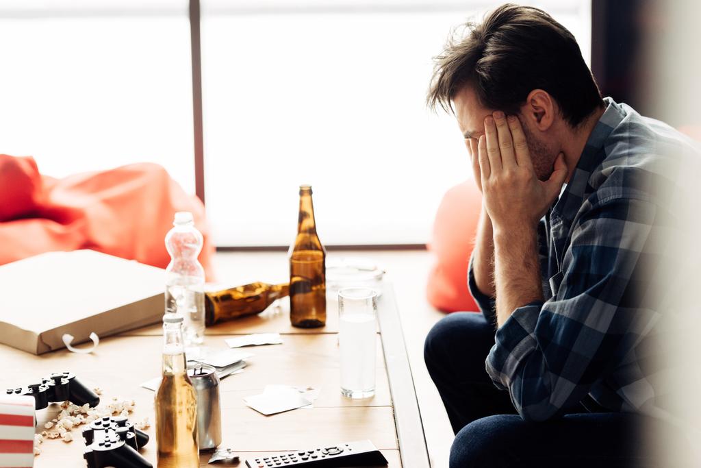 man covering face and suffering hangover after party - Photo, Image