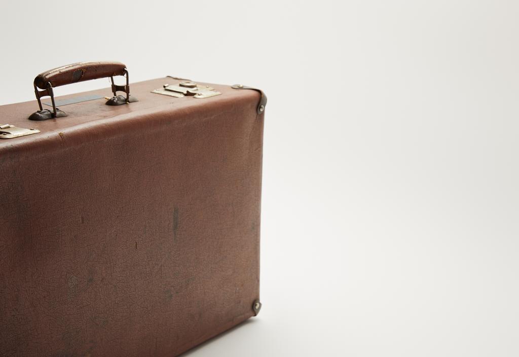Vintage bruine koffer op grijze achtergrond met kopie ruimte - Foto, afbeelding