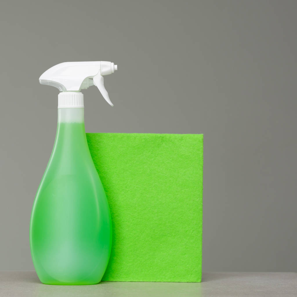Botella de spray verde de limpieza con dispensador de plástico y paño para el polvo
.  - Foto, Imagen