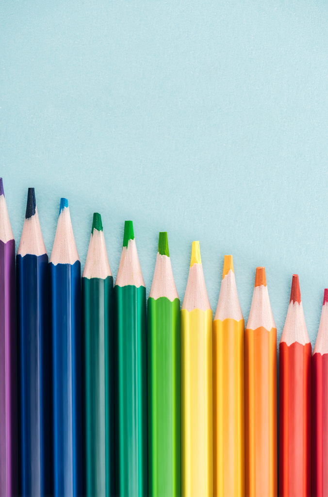 вид сверху радужных разноцветных карандашей, расположенных по диагонали на синем фоне, концепция lgbt
 - Фото, изображение