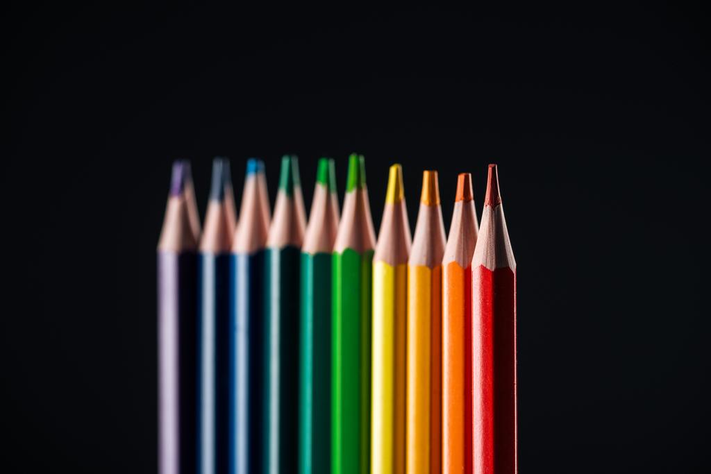 selectieve aandacht van regenboog gekleurde potloden geïsoleerd op zwart, holebi-concept - Foto, afbeelding