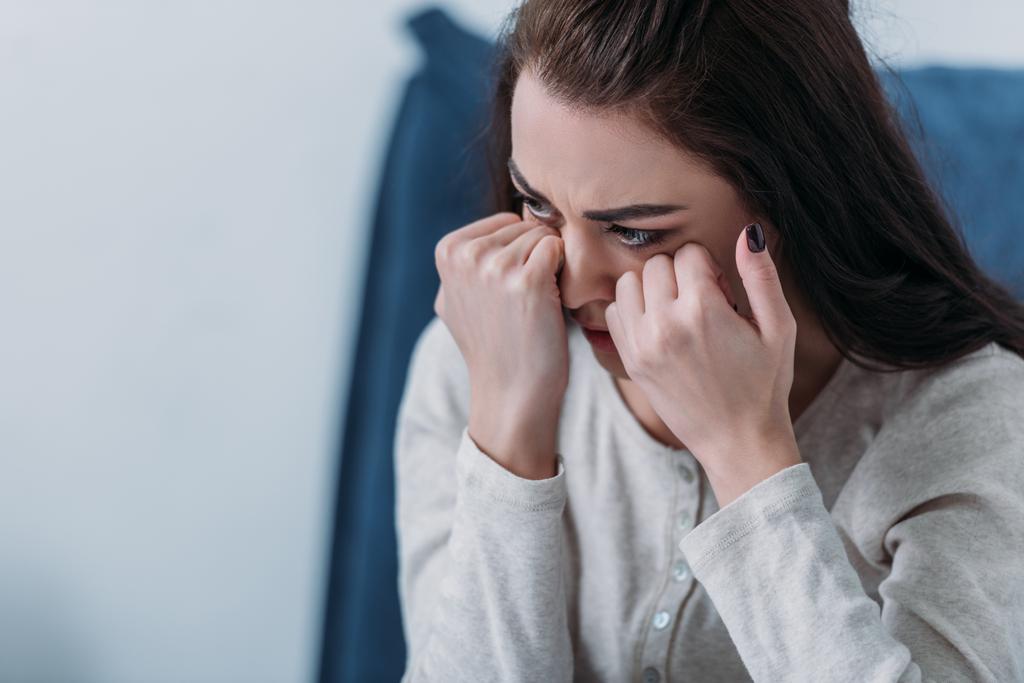 Selektiver Fokus einer depressiven Frau, die weint und Tränen mit Kopierraum wischt - Foto, Bild