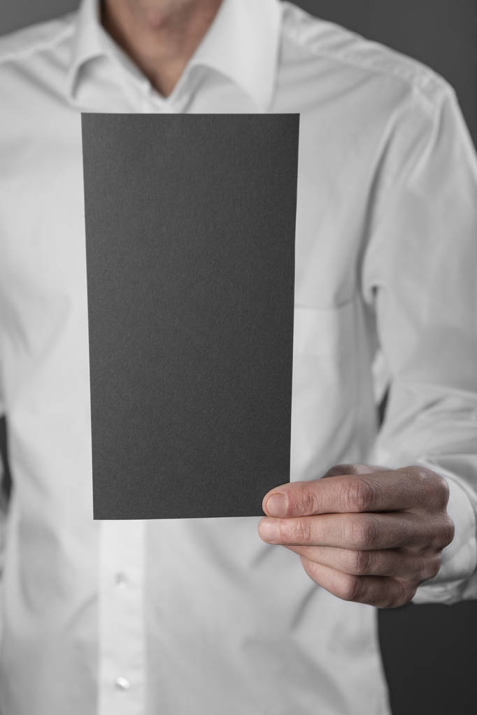 Чоловік тримає чорний буклет
 - Фото, зображення