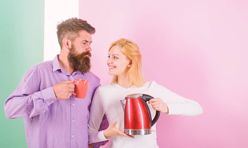 Spending good morning together. Couple prepare morning drink electric kettle device. Electric kettle boils water very quickly. Prepare favourite drink in minutes. Modern devices make our life easier - Photo, Image