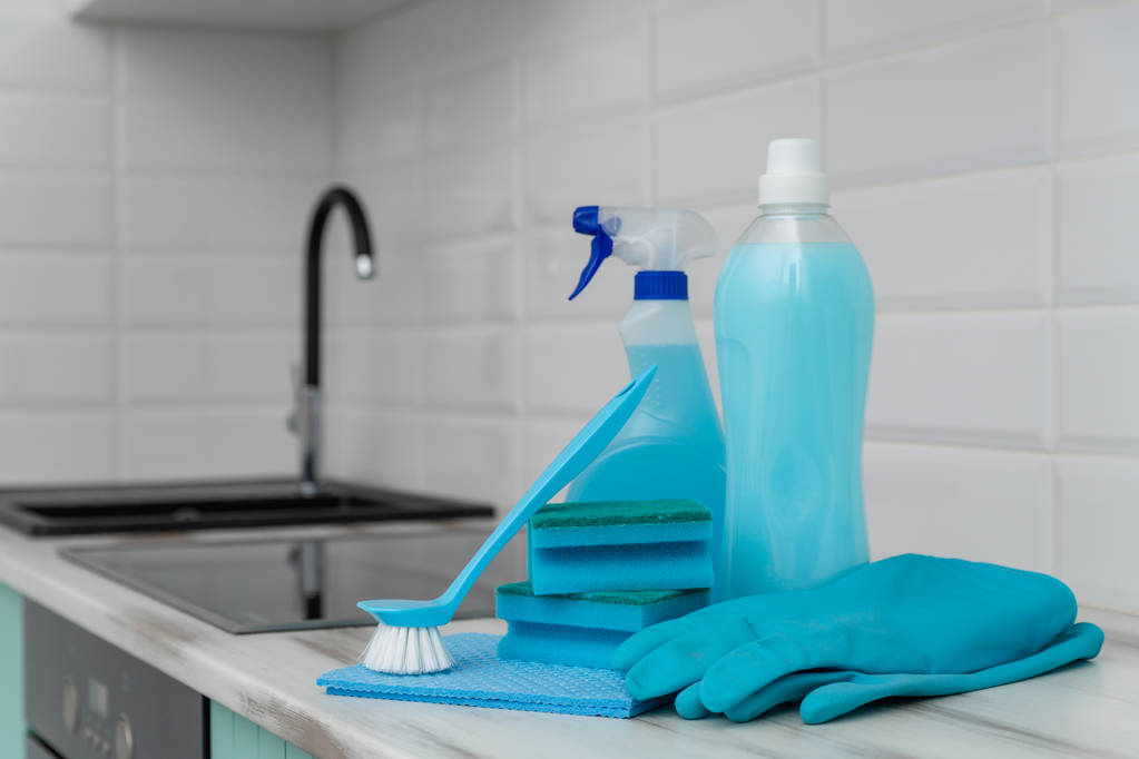 Un ensemble de produits de nettoyage bleus et des outils pour le nettoyage est sur la table de cuisine
. - Photo, image