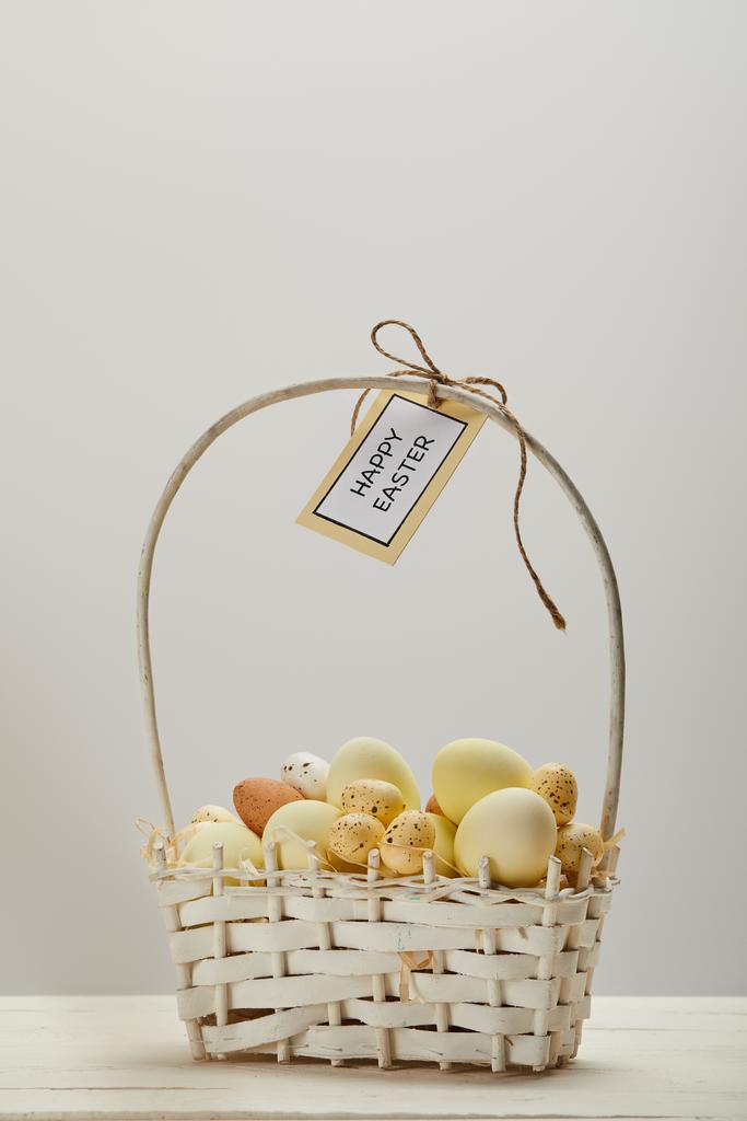 κοτόπουλο Πάσχα και ορτυκιού αυγά σε ψάθινο καλάθι με λουλούδι και κάρτα με ευτυχισμένο Πάσχα γράμματα - Φωτογραφία, εικόνα