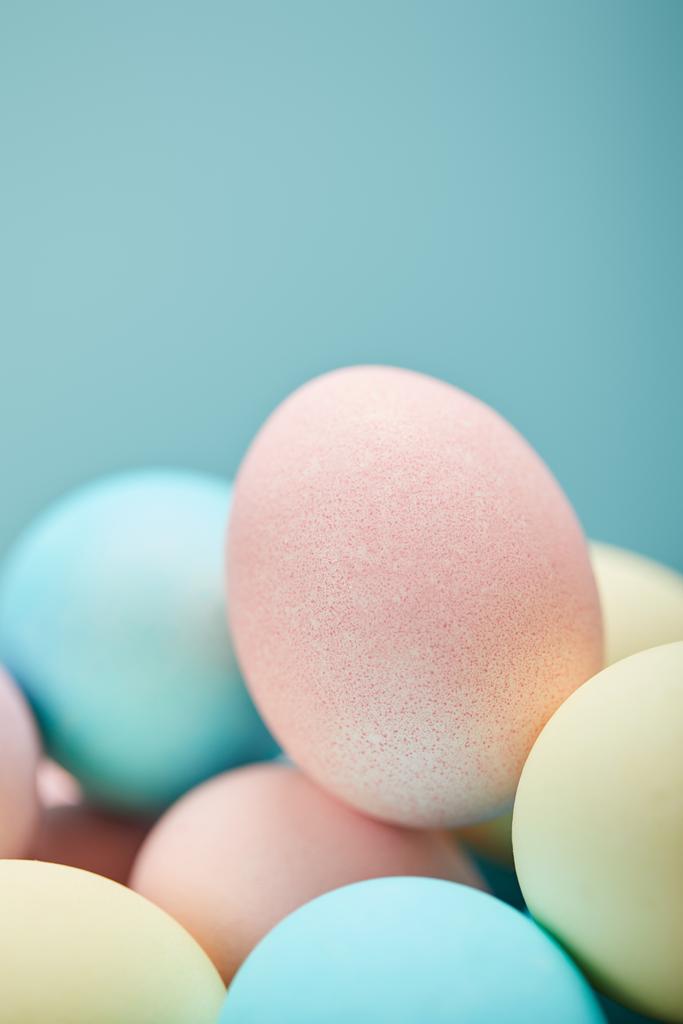 Selektivní fokus malovaná velikonoční vajíčka na modrém pozadí  - Fotografie, Obrázek