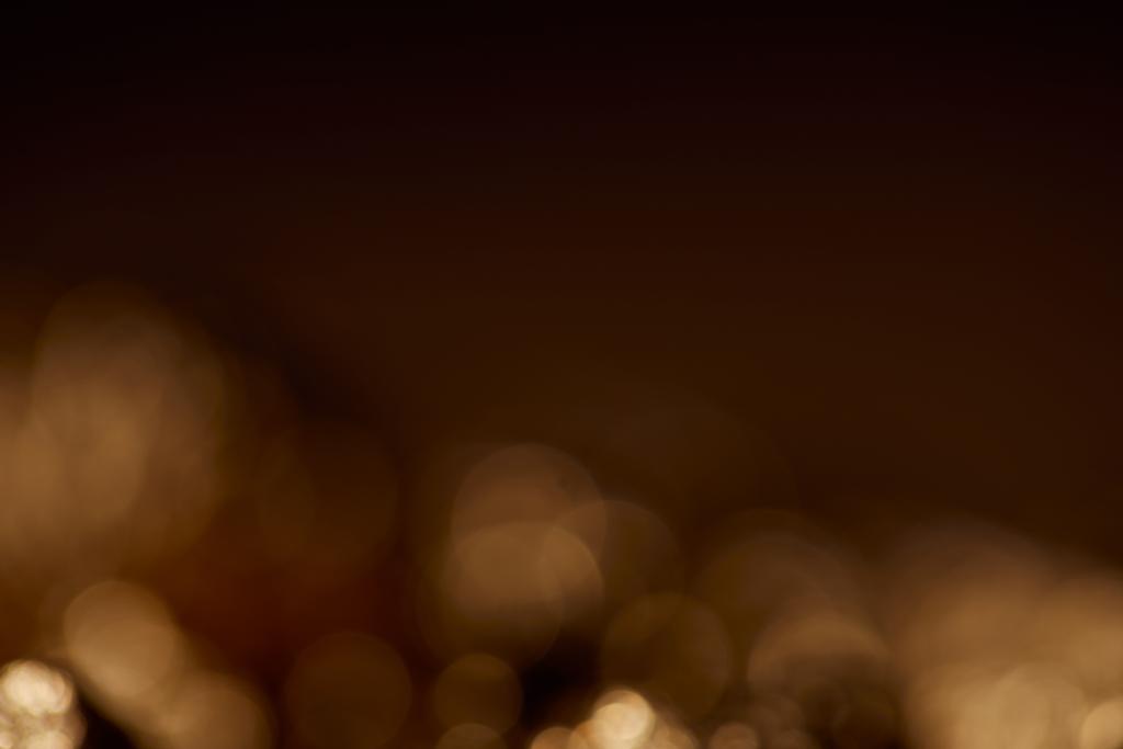 dunkelschwarzer Hintergrund mit goldenen glitzernden Lichtern - Foto, Bild
