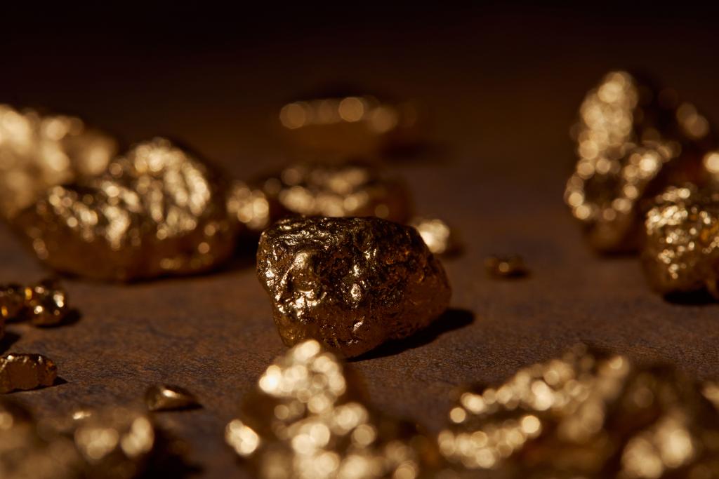 kahverengi mermer zemin üzerine altın taş seçici odak - Fotoğraf, Görsel