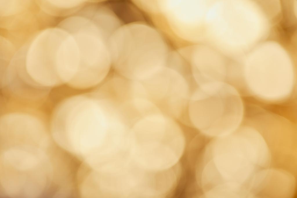 bright sparkles on blurred golden background - Photo, Image