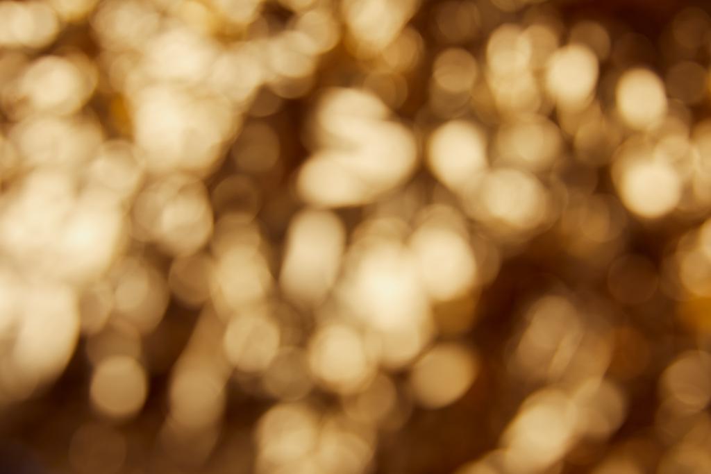 blurred bright twinkles and sparkles on golden background - Photo, Image