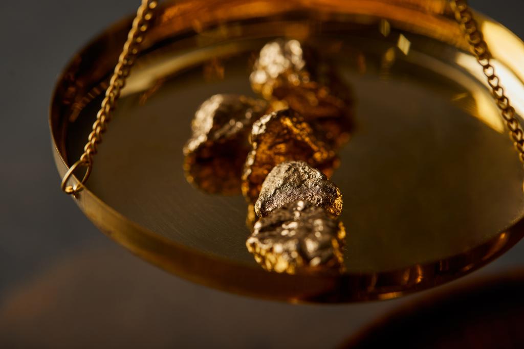 foco seletivo de pedras douradas em escalas em fundo cinza
 - Foto, Imagem