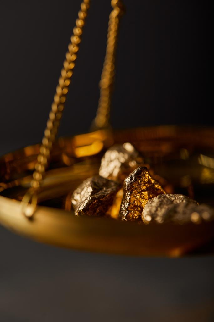 selective focus of golden stones on scales on dark blurred background - Photo, Image