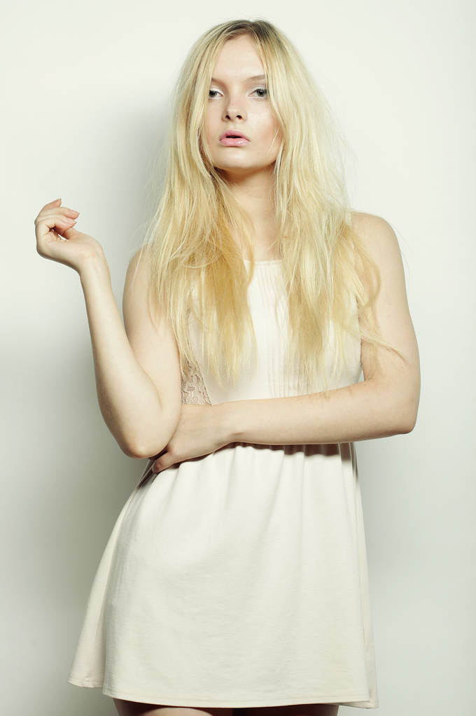 Блондинка в белом платье позирует в студии
 - Фото, изображение