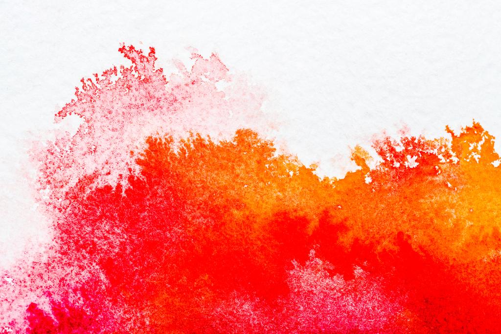 vista superior de derrames de acuarela roja y naranja sobre papel blanco
 - Foto, imagen