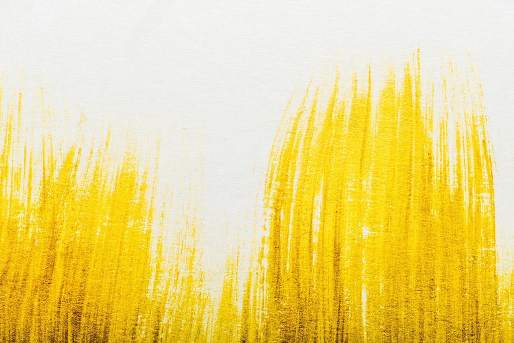 top view of yellow watercolor brushstrokes with on white paper  - Photo, Image
