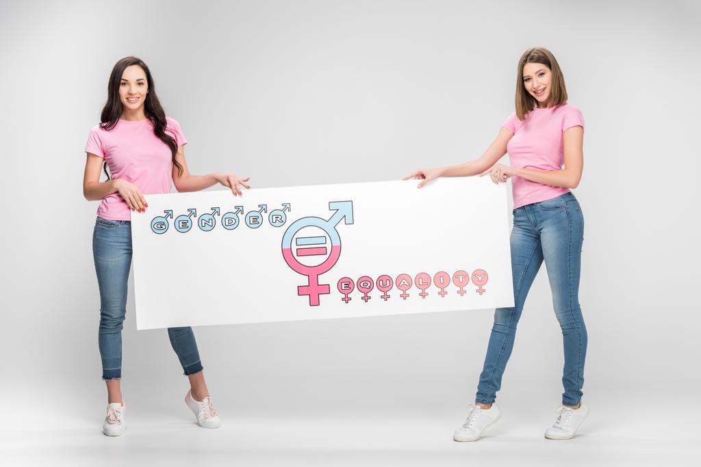 krásné ženy držící nápisem symbolem rovnosti pohlaví na šedém pozadí - Fotografie, Obrázek