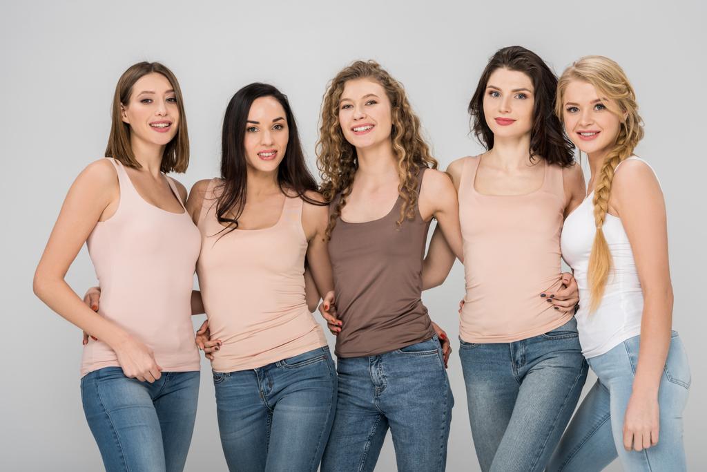 веселі молоді жінки посміхаються, стоячи разом ізольовані на сірому
  - Фото, зображення