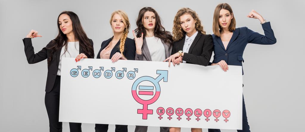 young businesswomen holding large sign with gender equality symbol isolated on grey  - Photo, Image