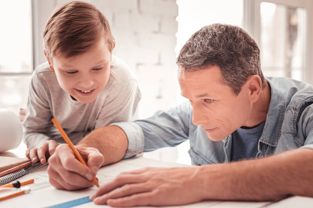 Rubia de pelo hijo viendo a su padre dibujar figuras para la clase de geometría
 - Foto, Imagen
