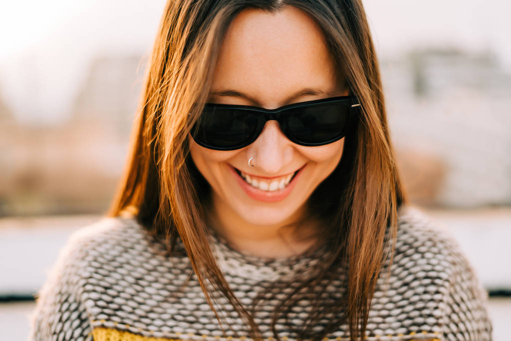 junge Frau lächelt mit Sonnenbrille  - Foto, Bild