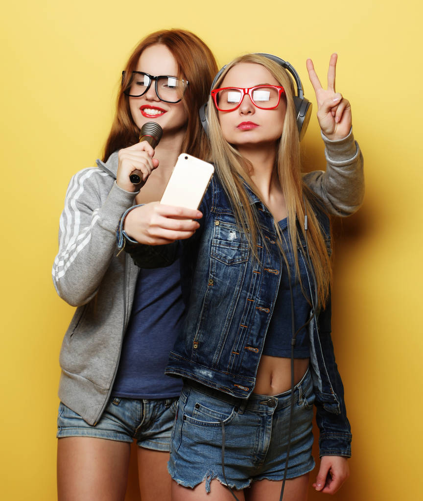 dvě dívky s mikrofonem zpěv a baví společně, aby selfie - Fotografie, Obrázek