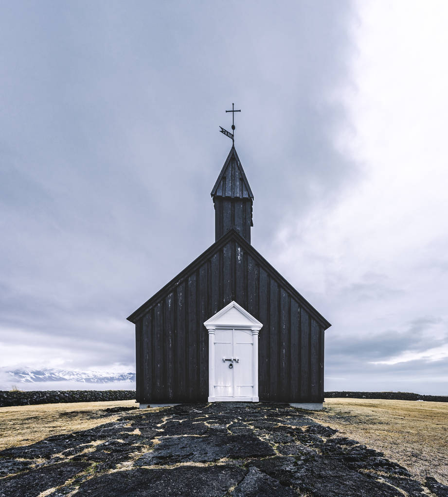 雪の多い天候の中、アイスランドのスネイフェルスネス半島地域のブドゥールの有名な絵のような黒い教会 - 写真・画像