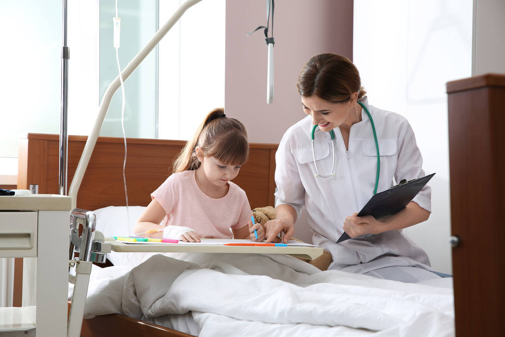 点滴医師の訪問の間に病院のベッドで図面と小さな子供 - 写真・画像