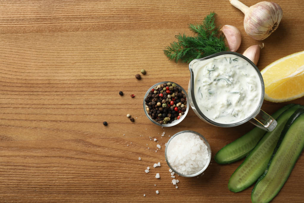 Cucumber sauce, ingredients and space for text on wooden background, flat lay. Traditional Tzatziki - Photo, Image